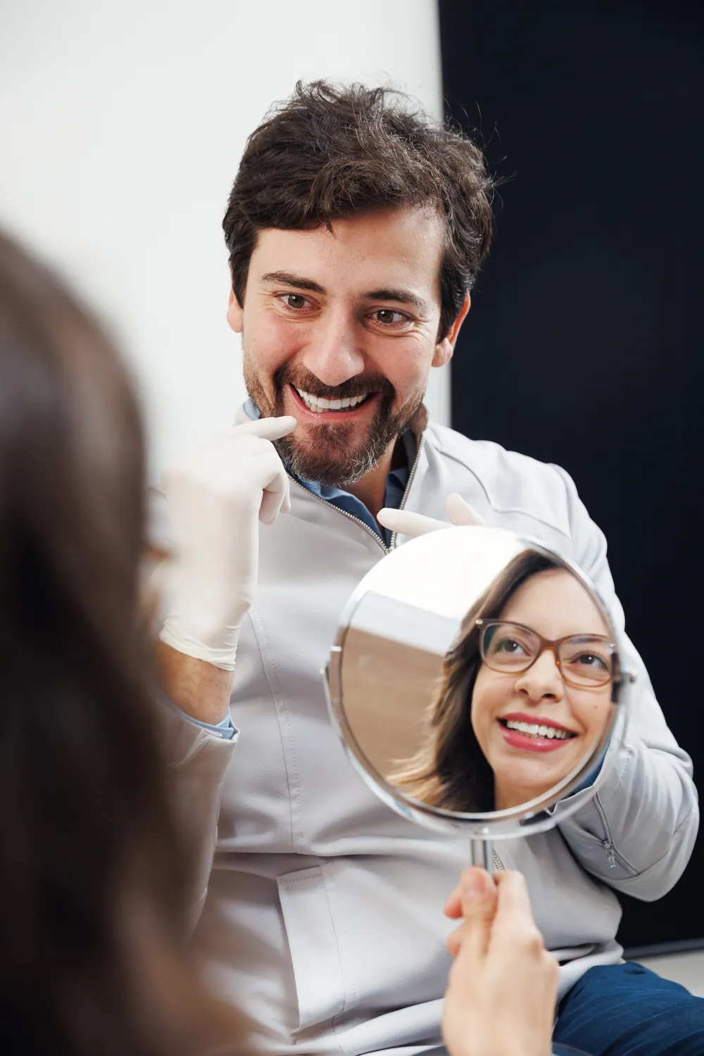 Paciente vendo o resultado do sorriso no espelho na OdontoID, em Mogi das Cruzes