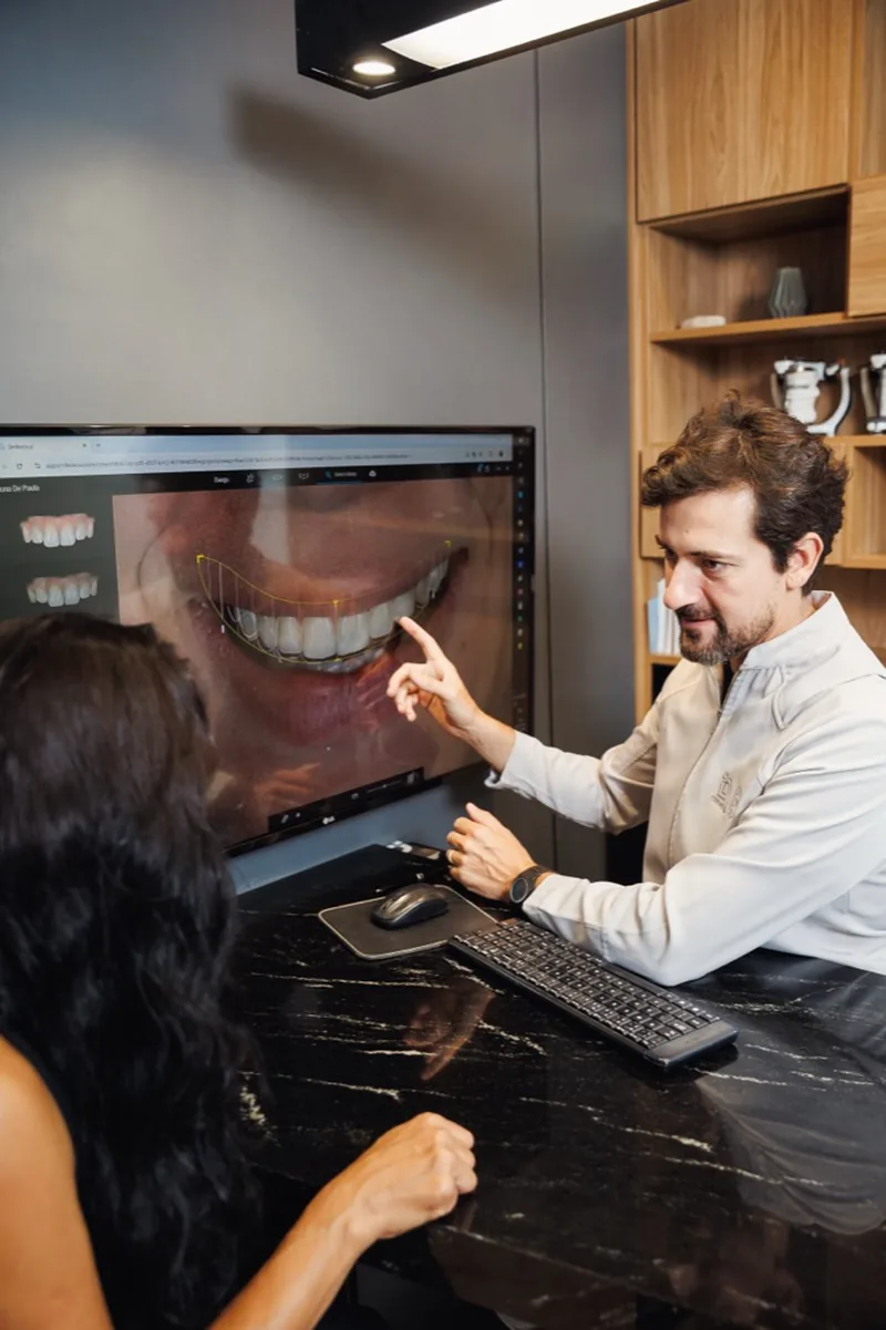 Dr. Diego Razé apresentando o planejamento digital do sorriso a uma paciente na OdontoID